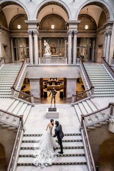 a bride and groom are standing on the stairs