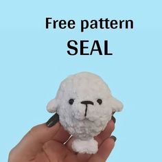 a hand holding a small stuffed animal with the words free pattern seal written on it