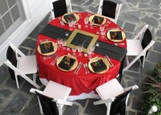 a red table with black and gold place settings