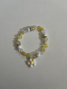 A yellow and white flower bracelet Cheap Yellow Flower Shaped Beaded Bracelets, Spring White Beaded Bracelets With Flower Charm, White Beaded Bracelets With Flower Charm For Spring, Cute White Flower Jewelry, Yellow Casual Bracelet Jewelry, Cute Flower Bracelets For Spring, Cute White Flower Bracelets, White Stretch Bracelet For Spring, Spring White Adjustable Stretch Bracelet