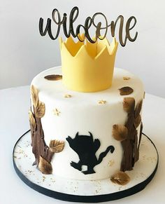 a white cake with a yellow crown on top and welcome written on the side that says,'welcome '