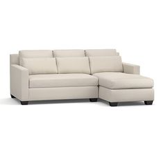 a white couch with a chaise lounger on it's legs and footrests