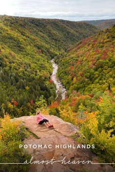 a woman sitting on top of a rock in the middle of a forest filled with trees