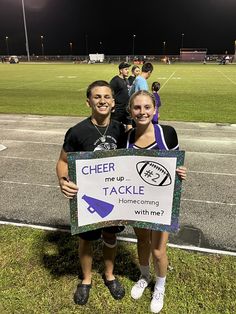 two people holding a sign that says cheer me up and tackle home coming with me