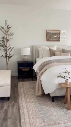 a bedroom with white walls and wood floors