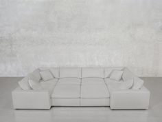 a large white couch sitting in front of a wall with no one on it's side