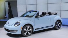 the volkswagen beetle convertible is on display at an auto show