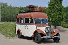 an old style bus with luggage on top