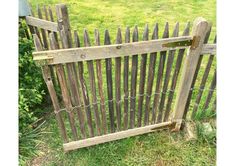 an old wooden gate is in the grass