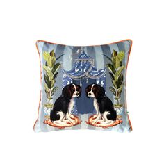 two black and white dogs sitting on top of a blue pillow