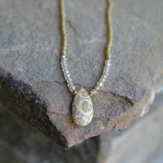 A fossil coral teardrop with nice pattern is combined with microfaceted golden natural zircon beads, 22k gold vermeil accents, and  golden glass seed beads, all strung on silk to give the necklace a nice drape on the neck.   17 inches 14k gold fill clasp Zircon Necklace, Fossil Coral, Glass Seed Beads, 22k Gold, Gold Vermeil, Fossil, Seed Beads, Beaded Necklace, Coral