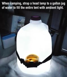 a bottle with a light inside it sitting on a blanket in the back of a car