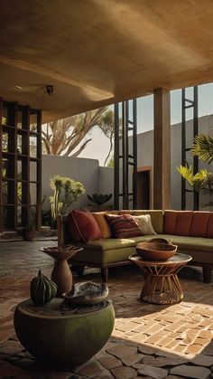 a living room filled with lots of furniture next to tall glass windows on top of a building