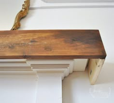 a wooden bench sitting on top of a white wall