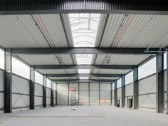 an empty warehouse with lots of windows and steel beams on the ceiling is seen in this image