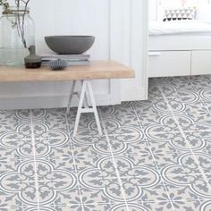 a white and gray tiled floor in a room with a table, vases and window