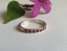 Handmade stackable and delicate silver Garnet ring for women, stoned with 7 red garnet gemstones. This silver garnet half eternity ring is available in other gemstones as well including blue sapphire (see photo), onyx, ruby, peridot and clear zirconia. Please choose your preferred gemstone on checkout. The red Garnet rings are designed in an antique vintage style and are beautiful for everyday wear, separately or stacked together for a mix of colors and beauty. Dimensions: The ring width is abou Garnet Stackable Promise Rings, Anniversary Stackable Garnet Gemstone Rings, Silver Half Eternity Birthstone Ring Gift, Ruby Half Eternity Jewelry Gift, Silver Ruby Half Eternity Promise Ring, Silver Ruby Promise Ring With Half Eternity Band, Garnet Stackable Rings As A Gift, Gift Ruby Ring With Half Eternity Round Band, Red Half Eternity Ring For Gift