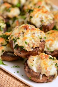 baked stuffed mushrooms with cheese and herbs on a white platter, ready to be eaten