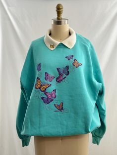 Super sweet grandma sweatshirt. On an aqua background it has embriodered buttrerflies on the front and one on right collar.  Would look awesome with a pair of high waisted jeans white socks and sneakers. -Vintage 90s -Collared, butterfly scene  -Machine wash recommended Measurements: *Sleeve 21 inches  *Bust 26 inches *Length 26 1/2 inches *Bottom opening 19 1/2 inches *This item is pre-loved and there may be minor flaws to the garment. Not to worry if there is anything major we will let you kno Vintage Blue Sweatshirt For Spring, White Socks And Sneakers, Sweet Grandma, Grandma Sweatshirt, Aqua Background, Collared Sweatshirt, Pull Sweat, Morning Sun