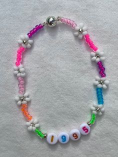 "Handmade, 7 inch, Neon Rainbow seed bead Bracelet. Super cute Bracelet, perfect for layering and beautiful to wear on its own as well. Available with or without personalization (name/date/initials). Makes a great gift and is perfect for friendship bracelets! Every bracelet is finished with a magnetic clasp for easy wearing. Primary color refers to the color in the center of the Daisy. The \"Clear\" primary color is available in glow-in-the-dark and a rainbow/AB finish. If selecting a non-metall Handmade Flower Shaped Beaded Bracelets For Birthday, Handmade Flower Shaped Beaded Bracelet For Birthday, Handmade Flower Beaded Bracelet For Birthday, White Beaded Bracelet For Birthday, Personalized White Beaded Bracelets For Festival, Handmade Rainbow Beaded Bracelets For Birthday, Handmade Rainbow Beaded Bracelet For Birthday, White Beaded Bracelets With Tiny Beads For Birthday, White Beaded Bracelet With Tiny Beads For Birthday