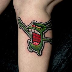 a tattoo on the leg of a person with an open mouth and tongue sticking out