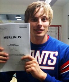 a young man holding up a piece of paper