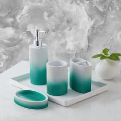 a bathroom set with soap dispenser, toothbrush holder and cups on a tray