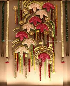 an intricately decorated wall hanging with flowers and beads