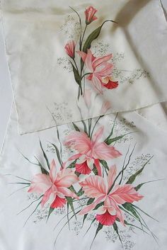 some pink flowers are on top of a white table cloth