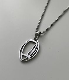 a silver necklace with a football on it