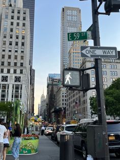 people are walking on the sidewalk in front of tall buildings and one way signs that read e 59 st