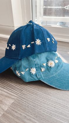 two hats sitting next to each other on the floor in front of an open window