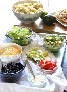 a table topped with bowls filled with different types of salads and condiments