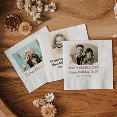 three personalized napkins on a wooden table with flowers and pine cones in the background