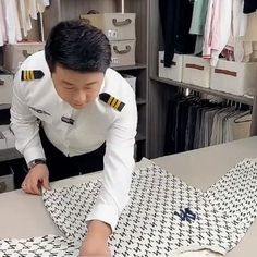 a man in uniform cutting up a piece of fabric