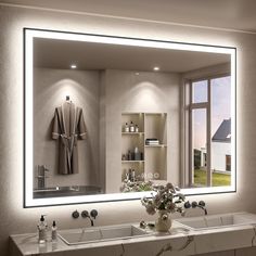 a bathroom with a large mirror and two sinks in front of the mirror is illuminated by lights