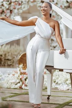 a woman standing next to a white piano