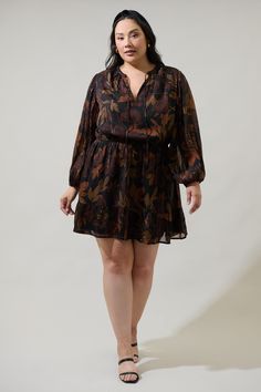 You'll be looking beyond gorgeous in the Larba Floral Paxton Balloon Sleeve Mini Dress. It features a split neckline with a tie detail that's framed by sheer, long balloon sleeves. An elastic band at the waist creates shape, topping a gathered flowy single tier skirt. Pair it with strappy heels and a black matching bag. - Split neckline- Balloon sleeves- Elastic waist- Lined- Color: Black BrownSize + Fit - Model is 5'9" and wearing size 2X- Measurements taken from size 2X- Chest: 26 3/4"- Length Black Long-sleeve Dresses With Blouson Sleeves, Black Long Sleeve Dresses With Blouson Sleeves, Black Long Sleeve Dress With Blouson Sleeves, Fall Black Dress With Blouson Sleeves, Black Fall Dress With Blouson Sleeves, Black Balloon Sleeve Dresses For Fall, Black Balloon Sleeve Dress For Fall, Balloon Sleeve Top, Long Balloons