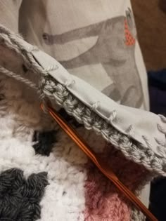 the crochet is being worked on by someone using knitting needles to sew