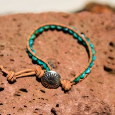 Created by the artists at Alta Studios this Turquoise Bead and Leather Wrap bracelet is hand crafted high in the mountains of Northern New Mexico. Made from genuine high quality turquoise rondelle beads, tan Greek leather cord and cast metal "Concho" button. A beautiful piece of the Southwest! This item is one of a kind - you will receive the exact item pictured. Adjustable length : Approx. 7 3/8" to 8" dia. 12 oz. Shipping Weight Northern New Mexico, Turquoise Leather, Leather Wrap Bracelet, Metal Casting, Leather Wraps, In The Mountains, Turquoise Beads, Leather Cord, New Mexico