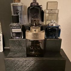 an assortment of men's perfumes and cologne bottles on a shelf in a bathroom