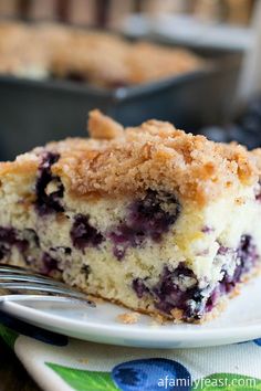 a piece of blueberry coffee cake on a white plate with a bite taken out