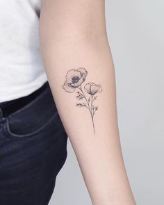 a woman's arm with three flowers on the left side of her arm and one flower in the middle