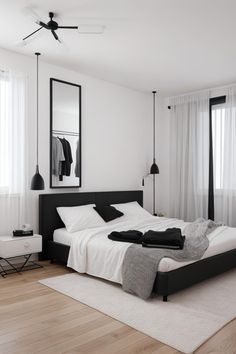 a white and black bedroom with a bed, mirror, dresser and window sill