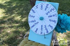 a blue and white wheel of fortune sitting on top of a basket next to a tree