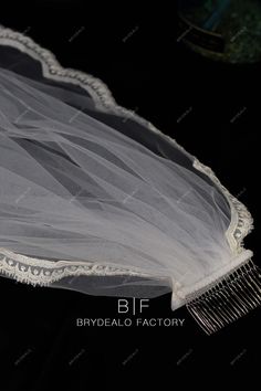 the bridal hair comb is laying on top of a veiled piece of cloth