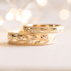 two gold wedding bands with diamonds on them