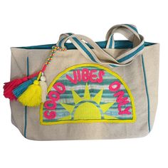 Carry your beach, pool, or lake essentials in style with this "Good Vibes Only" tote bag. Embroidered yarn detail and fun, bright colors add a playful touch to any beach day. Spread positive vibes wherever you go - only good vibes allowed! 21” x 15.5” Sunshine Patch Beach Tote Snap Closure Fun Decorative Tassels Canvas fabric Over the shoulder straps Interior Pockets Trendy Green Canvas Beach Bag, Bohemian Beach Bag Made Of Canvas, Multicolor Embroidered Tote Beach Bag, Trendy Summer Beach Bag For Weekends, Canvas Beach Tote Bag For Vacation, Canvas Tote Beach Bag For Vacation, Blue Beach Bag For Poolside Use, Trendy Canvas Beach Bag For Beach Season, Green Beachy Tote Beach Bag