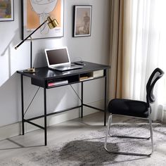 a laptop computer sitting on top of a black desk next to a chair and lamp