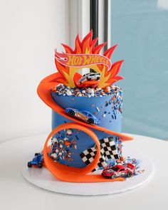 a birthday cake decorated with cars and flames